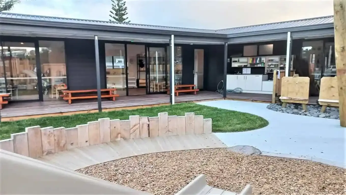 The centre's covered deck and courtyard, with timber seating, an easel and a grassed circle.